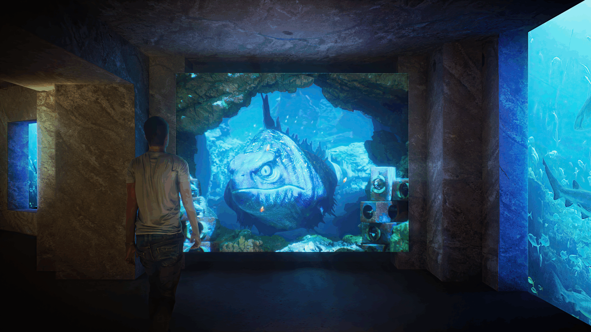 Eine Person interagiert mit einer raumhohen Videoprojektion eines Fisches im Aquariumskorridor „Lost World“.